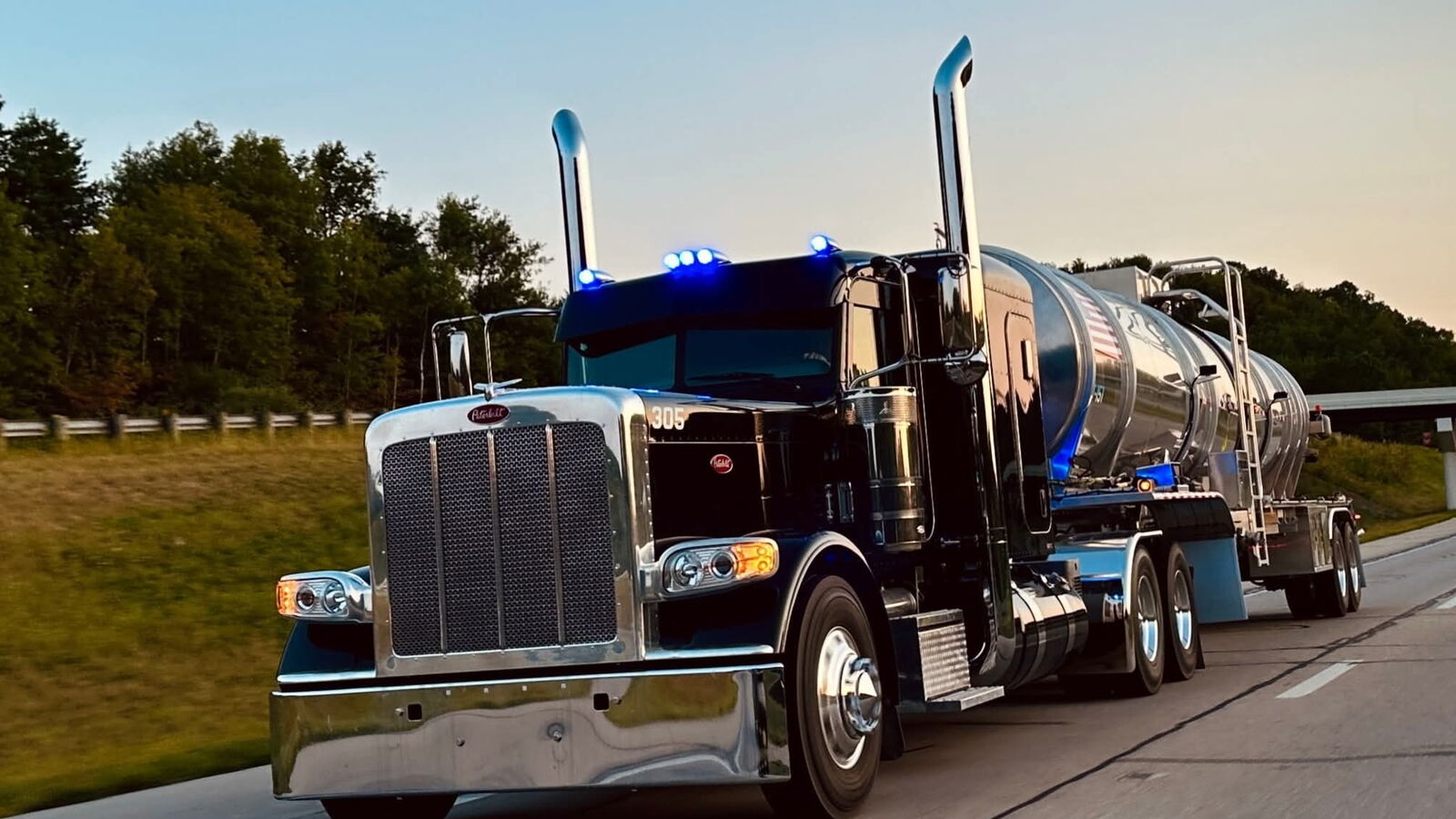 Titan Oil Peterbilt 305 pulling a crude tanker down the highway at dusk