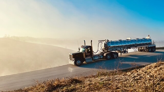 Titan water truck rolling down a lease road in the morning haze